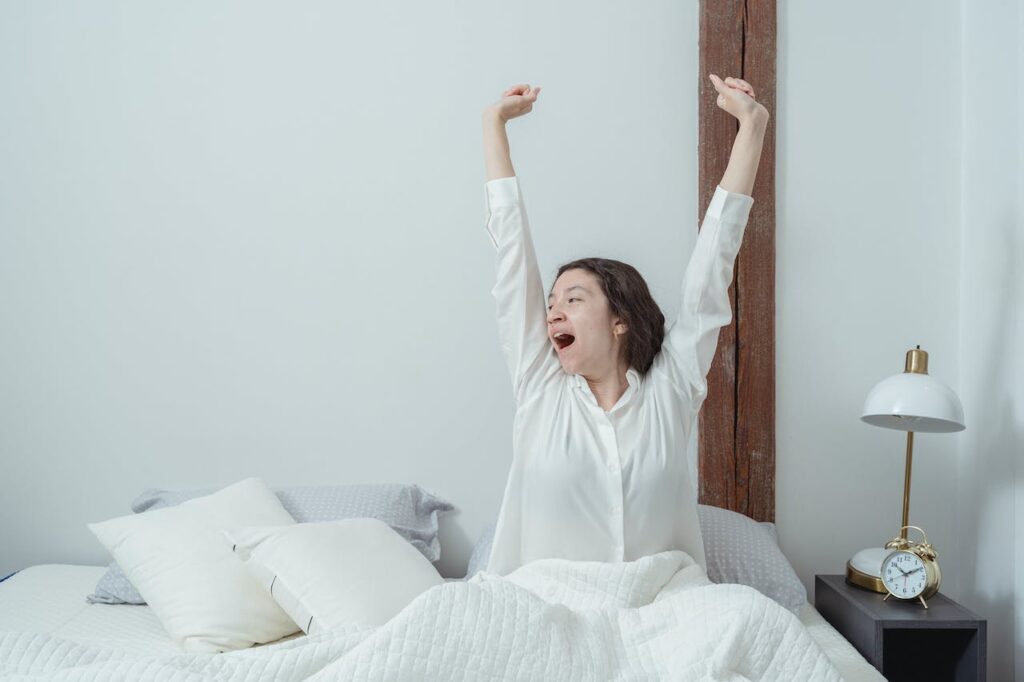 a woman waking up from bed: how to wake up early